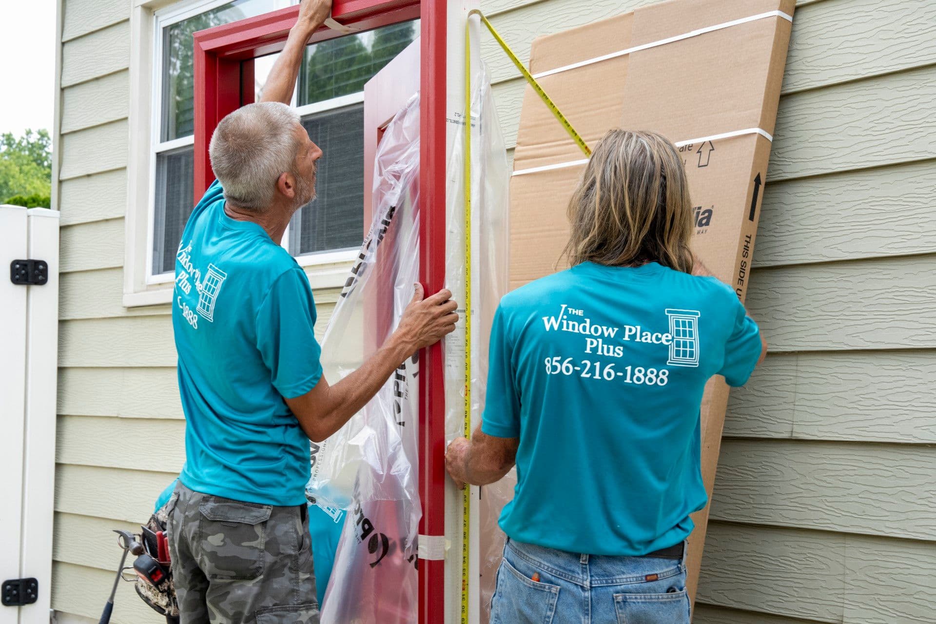 2 people working on installing a new door