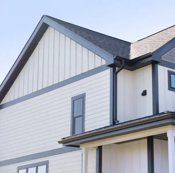 Modern house exterior with light beige siding and dark trim, gable roof, and narrow windows. The clean lines and soft colors create a calm, contemporary feel.