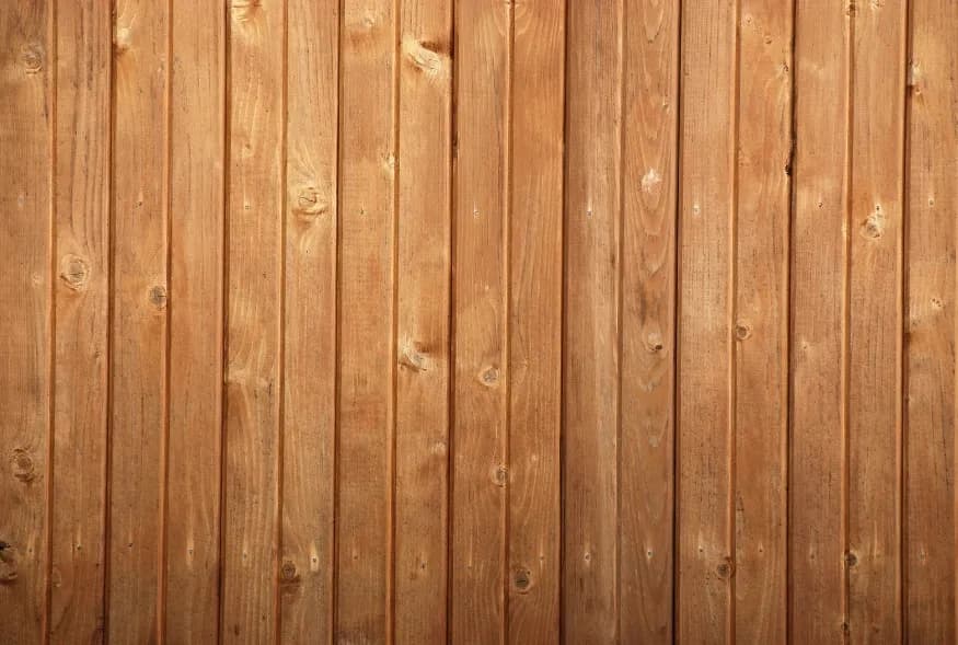 Wooden planks with visible natural grain and knots arranged vertically, creating a rustic and warm texture. The tone is earthy and inviting.